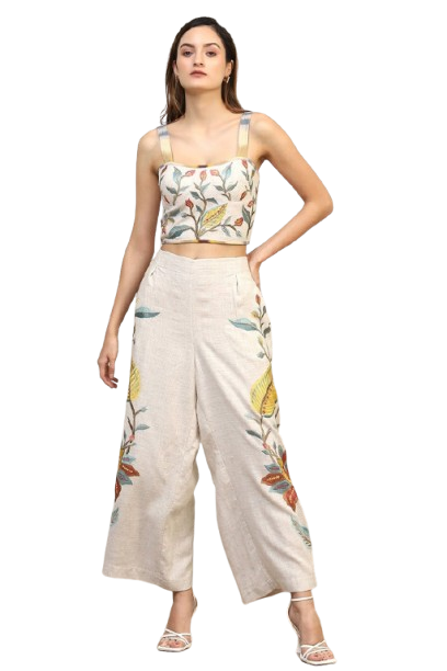 Woman wearing a floral embroidered crop top and wide-leg pants set.
